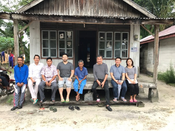 foto bersama di depan rumah tradisional penduduk